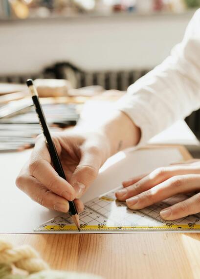 Person using a physical ruler on paper for design work