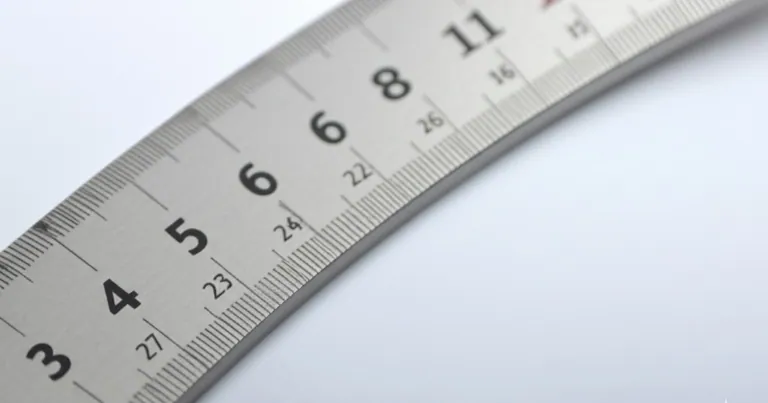 Metal ruler being aligned for technical blueprint drafting